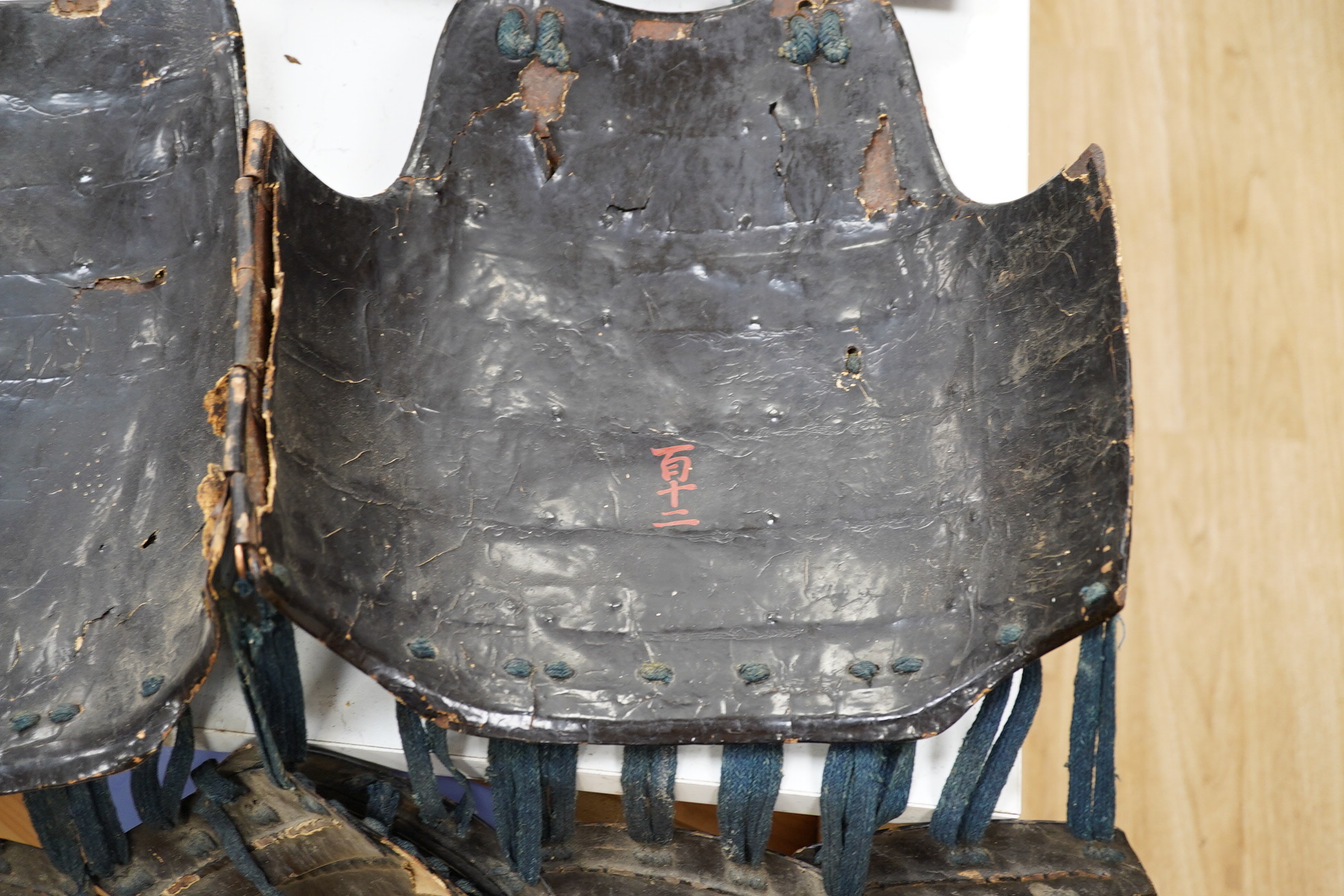 A Japanese armour, 19th century or earlier comprising; helmet Kabuto of five plates covered in black lacquer with 4-plate shikoro, also an iron lacquered mempo with three lames to throat and a do opening at side, embosse